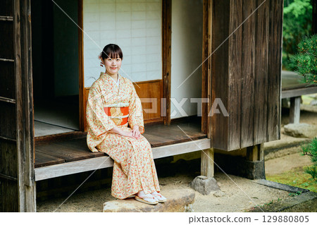 A woman in a kimono quietly standing on the veranda A woman in a kimono quietly standing on the veranda 129880805