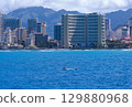 A canoe paddles in the ocean in Waikiki and the skyscrapers 129880968