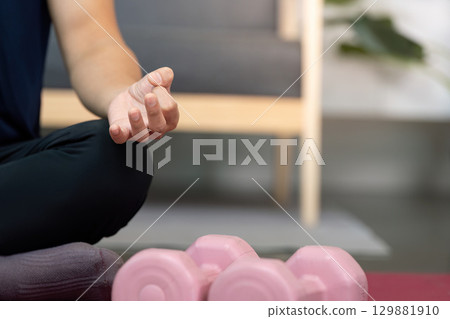 Mindfulness and Wellness. Close-up of man meditating with weights. 129881910