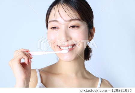 Image of a woman brushing her teeth Image of a woman brushing her teeth 129881955