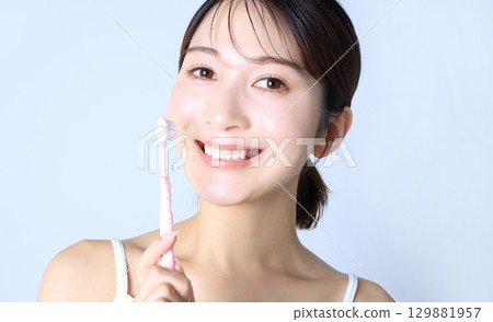 Image of a woman brushing her teeth 129881957