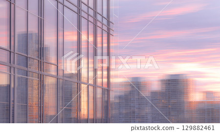 Urban landscape glows with pink and orange hues as buildings reflect a tranquil summer sunset. 129882461