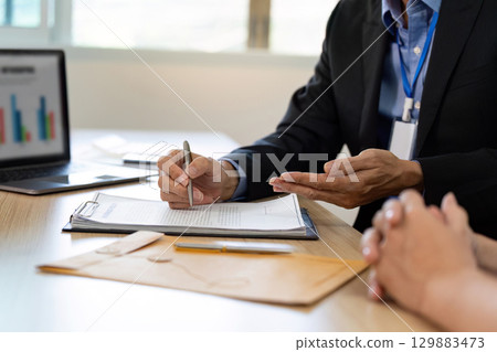 Insurance Consultation. Businessman discussing policy details with client in office. 129883473