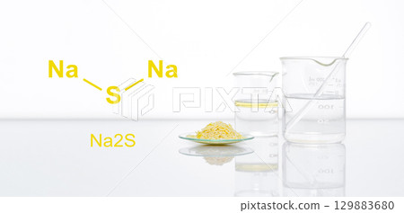 Sodium sulfide flake in Chemical Watch Glass place next to beaker on white laboratory table. The structure of a chemical compound is shown on the side. 129883680
