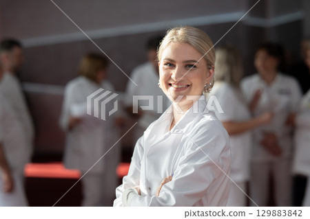 Young female doctor posing in front of medical staff 129883842