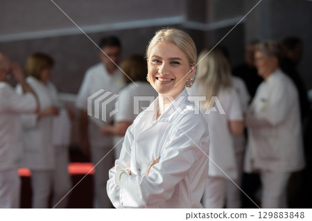 Young female doctor posing in front of medical staff 129883848