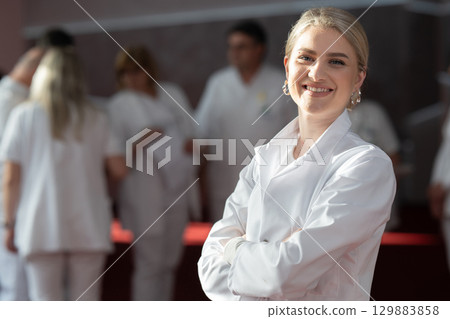 Young female doctor posing in front of medical staff 129883858
