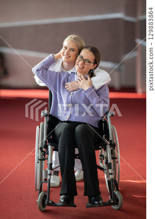 Young nurse hugging elderly woman in wheelchair 129883864