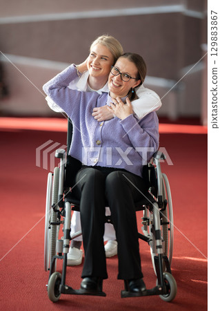 Young nurse hugging elderly woman in wheelchair 129883867