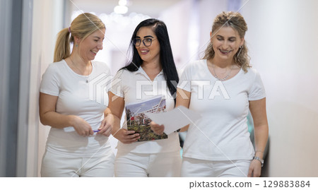 Group of smiling nurses walking in hospital hallway 129883884