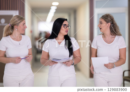 Group of smiling nurses walking in hospital hallway 129883900