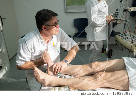 Doctors performing patient diagnostics with equipment 129883982