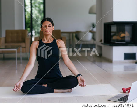 Young Beautiful Female Exercising, Stretching and Practising Yoga with Trainer via Video Call Conference in Bright Sunny House. Healthy Lifestyle, Wellbeing and Mindfulness Concept. 129884071