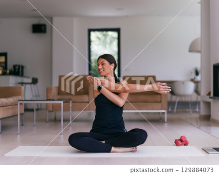 Young Beautiful Female Exercising, Stretching and Practising Yoga with Trainer via Video Call Conference in Bright Sunny House. Healthy Lifestyle, Wellbeing and Mindfulness Concept. 129884073