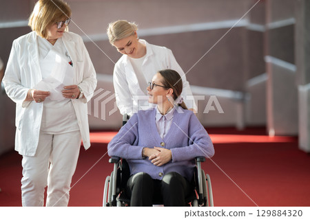 Doctor checking patients progress in wheelchair 129884320