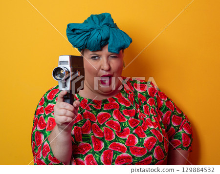 Retro plus size woman filming with vintage camera Retro plus size woman filming with vintage camera 129884532