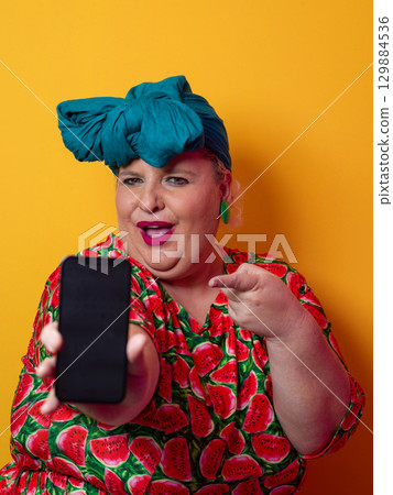 Plus size woman pointing at smartphone with excitement 129884536
