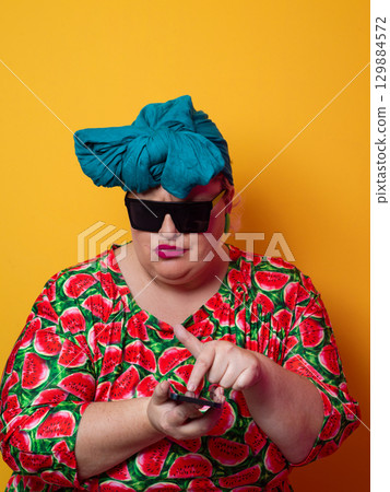 Surprised plus-size woman looking at smartphone with wide expression Surprised plus-size woman looking at smartphone with wide expression 129884572