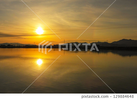 Morning sun reflected on the surface of a winter lake 129884648