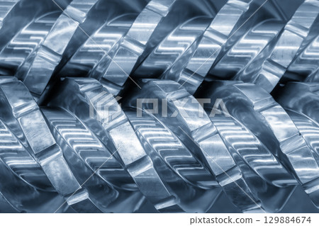 Close up scene body of the barrel screw of injection machine spare parts in the blue tone scene. Close up scene body of the barrel screw of injection machine spare parts in the blue tone scene. 129884674