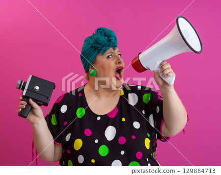Shouting woman holding megaphone and vintage camera 129884713