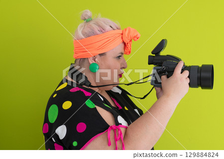 Side view of woman filming with video camera 129884824