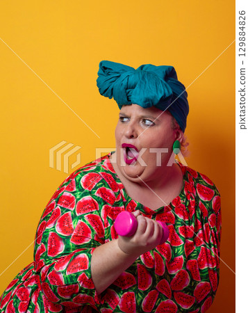 Exhausted plus size woman resting after dumbbell workout 129884826