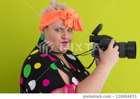 Side view of woman filming with video camera 129884833
