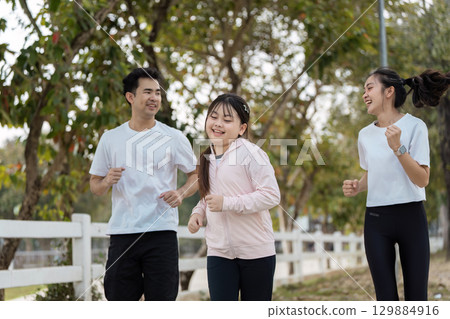 Happy Family Enjoying Outdoor Exercise Together in a Park Setting on a Sunny Day 129884916