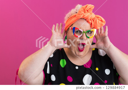 Excited woman with hands raised in surprise Excited woman with hands raised in surprise 129884917