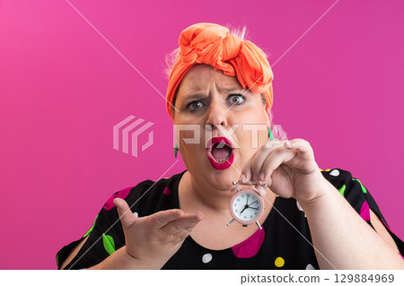 Playful woman in colorful outfit pointing with excited expression Playful woman in colorful outfit pointing with excited expression 129884969