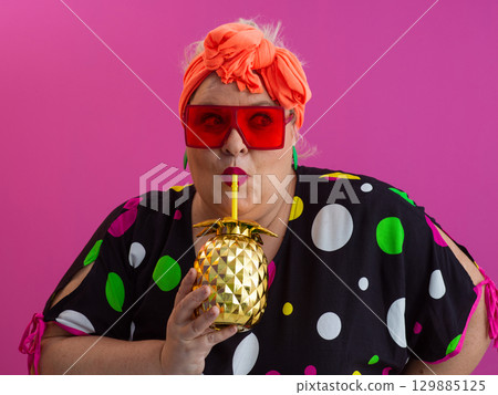 Stylish Woman with Pineapple Drink Against Pink Background 129885125