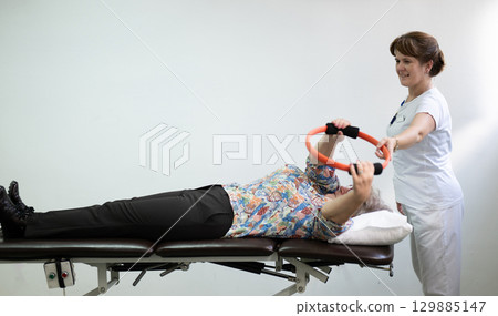 Physiotherapy Session with Elderly Woman Using Exercise Ring 129885147