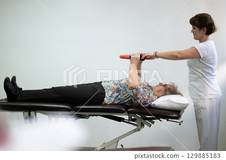 Physiotherapy Session with Elderly Woman Using Exercise Ring Physiotherapy Session with Elderly Woman Using Exercise Ring 129885183