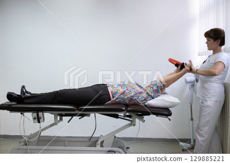 Physiotherapy Session with Elderly Woman Using Exercise Ring Physiotherapy Session with Elderly Woman Using Exercise Ring 129885221