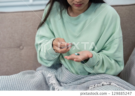Woman Taking Medication at Home While Feeling Unwell, Healthcare and Recovery Concept Woman Taking Medication at Home While Feeling Unwell, Healthcare and Recovery Concept 129885247