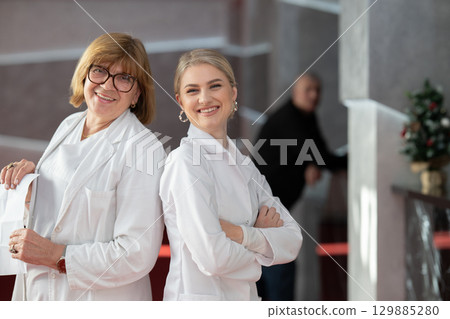 Healthcare workers smiling back to back in clinic 129885280