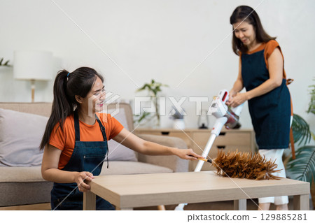 Professional Housekeeper Performing Cleaning Tasks in a Modern Home Environment with Vacuum and Dusting Tools Professional Housekeeper Performing Cleaning Tasks in a Modern Home Environment with Vacuum and Dusting Tools 129885281