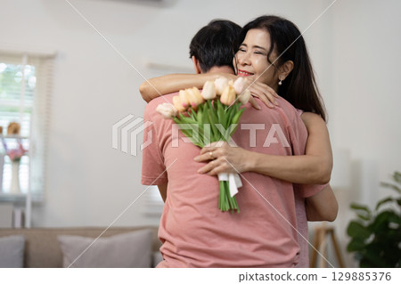 Senior Couple Celebrating Valentine's Day with Love and Joy in a Cozy Home Setting 129885376