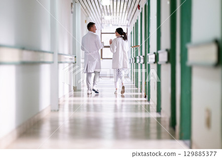 Doctors Walking in Hospital Hallway 129885377