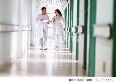 Doctors Walking in Hospital Hallway 129885379