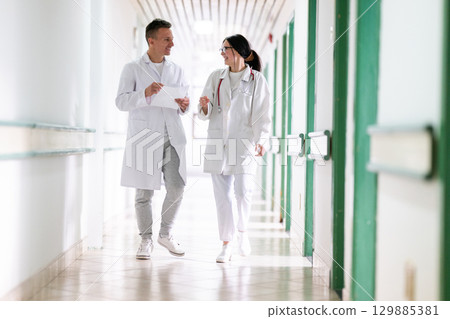 Doctors Walking in Hospital Hallway 129885381