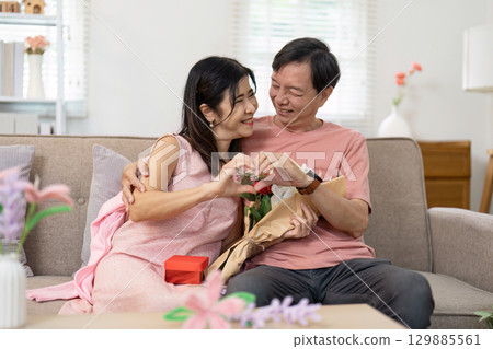 Senior Couple Celebrating Valentine's Day with Flowers and Gifts in Cozy Home Setting Senior Couple Celebrating Valentine's Day with Flowers and Gifts in Cozy Home Setting 129885561