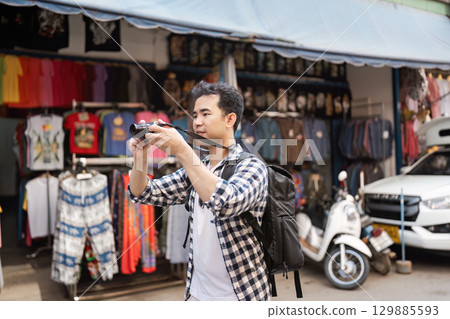 Traveler Exploring Vibrant Street Market Capturing Memories with Camera in Hand 129885593