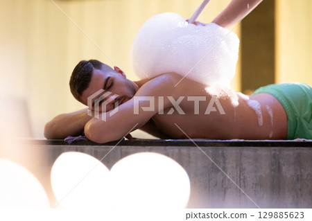 Foam Massage Session.Hamam attendant applying foam massage on patient back with circular motions. 129885623