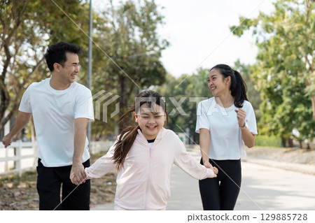 Happy Family Enjoying Outdoor Wellness Activities Together in a Park Setting Happy Family Enjoying Outdoor Wellness Activities Together in a Park Setting 129885728