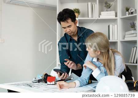 Engineers Collaborating on Architectural Design Project in Modern Office Setting 129885739