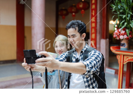 Couple Exploring Cultural Landmarks on Vacation, Capturing Memories with a Camera in a Vibrant Historical Setting 129885760