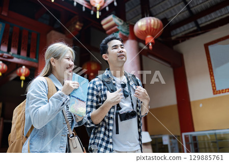 Joyful Travelers Exploring a Vibrant Asian Market with Maps and Cameras, Immersed in Culture and Adventure 129885761