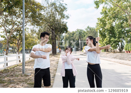 Happy Family Enjoying Outdoor Exercise Together in a Park Setting Promoting Health and Wellness 129885919